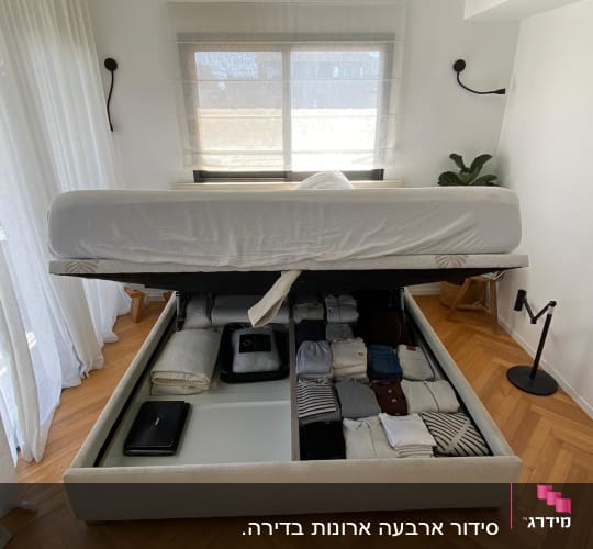 מיטה עם אחסון תחתון פתוח, בגדים מקופלים ומסודרים